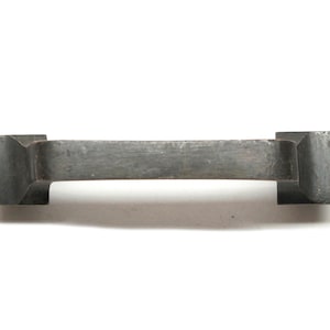 Könnte beinhalten: Ein schwarzer Metall-Schrankgriff mit rechteckiger Form und einem gebogenen Griff.