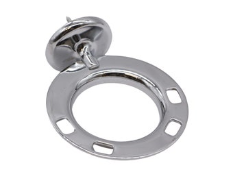 May include: Chrome-plated metal ring with four mounting holes and a small, round, chrome-plated cap with a screw. The ring is designed to be mounted on a surface.