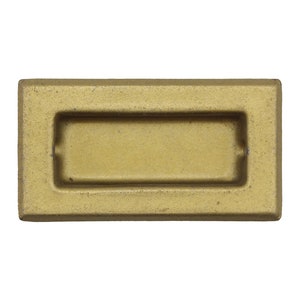 Puede incluir: Un tirador de armario rectangular de metal de color dorado con una abertura rectangular empotrada.