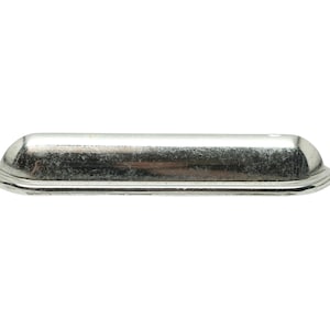 May include: A silver-toned, rectangular cabinet pull with rounded edges and a slightly raised center.