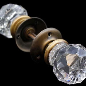 Puede incluir: Un pomo de puerta vintage con dos pomos de cristal transparente y una base de latón.
