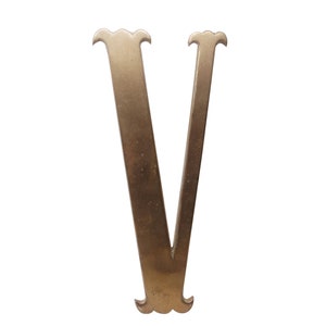 Peut inclure: Une lettre V en métal doré avec des fioritures décoratives en haut et en bas.