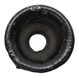 May include: Black ceramic pottery piece with a circular opening in the center. The piece is smooth and has a slightly uneven surface.