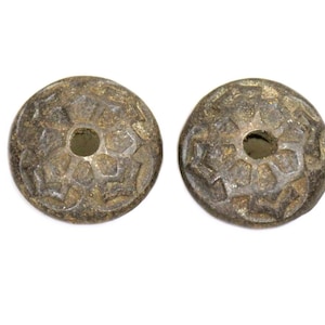 Op de afbeelding: Twee antieke ronde kralen van brons met een decoratief geometrisch patroon en een gat in het midden.