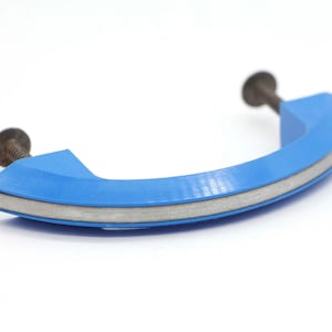May include: A blue plastic cabinet door handle with a silver trim and a screw on each end.