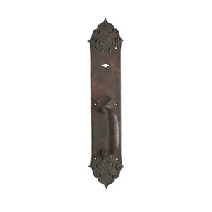 Puede incluir: Un tirador de puerta de estilo vintage, de color marrón oscuro, con una placa trasera ornamentada y alargada. El tirador tiene un agarre curvo y está montado sobre una placa rectangular con patrones decorativos en forma de hojas en la parte superior e inferior.