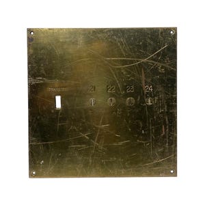 May include: A brass plate with the word "TRANSFER" and numbers 21, 22, 23, and 24 engraved on it. The plate has a worn, aged appearance.