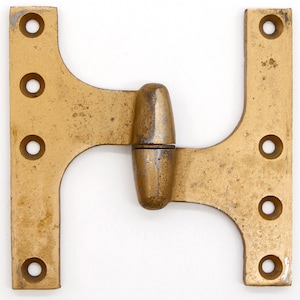 Puede incluir: Una bisagra de metal dorado con cuatro agujeros a cada lado. La bisagra está diseñada para conectar dos superficies en un ángulo de 90 grados.