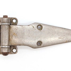 May include: A silver-toned metal hinge with a rounded, slightly rusted pin. The hinge is designed for a door or cabinet and has multiple holes for screws.