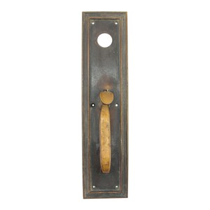 May include: Antique brass door handle with a rectangular backplate and a long, curved lever. The handle is mounted on a wooden door.