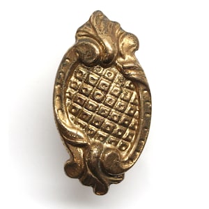 Könnte beinhalten: Ein goldfarbener, dekorativer Türknauf aus Metall mit einem Diamantenmuster und verzierten Schnörkeln.