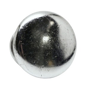 May include: A silver-toned metal knob with a smooth, rounded surface. The knob has a slight shine and shows signs of wear.