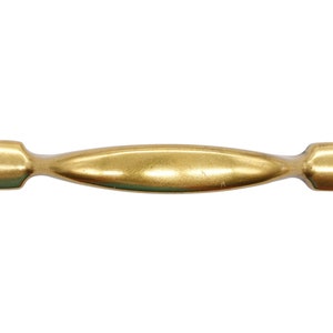 May include: A gold-toned cabinet pull with a slightly curved shape and rounded ends.