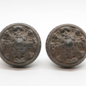 May include: Two antique black metal door knobs with a floral design.