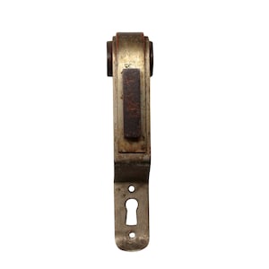 May include: A vintage metal door handle with a wooden insert and a keyhole. The handle is silver with a brass finish and has a rounded top.