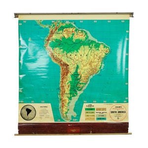 May include: A vintage, rolled-up map of South America with a green and yellow color scheme. The map is labeled "Cram's Physical Map of South America".