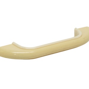 May include: A cream-coloured plastic handle with a rounded shape and a slightly raised edge.