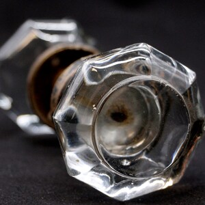 Könnte beinhalten: Ein klarer gläserner Türknauf mit sechseckiger Form und Messingbasis.