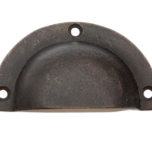 May include: A half-round, antique brass cabinet pull with a smooth, slightly textured surface and three holes for mounting.