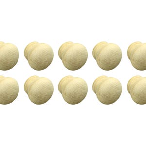 May include: Ten wooden knobs in a light beige colour. The knobs are round and have a slightly raised centre.