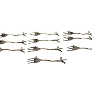Könnte beinhalten: Satz von zehn silberfarbenen Schrankgriffen in Form einer Gabel mit einem Zweigdesign.