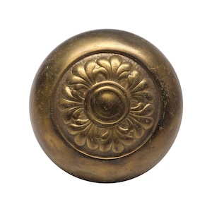 May include: A gold-toned metal knob with a decorative floral design.
