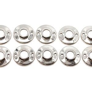 Könnte beinhalten: Zehn silberfarbene Türknauf-Rückplatten aus Metall. Jede Rückplatte ist rund mit einem Loch in der Mitte und zwei kleinen Löchern an der Seite.