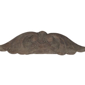 May include: A carved wooden decorative piece shaped like a stylized mustache. The piece is dark brown and has a smooth, worn surface.