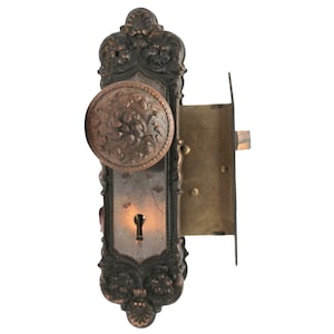May include: Antique brass door knob and lock set with ornate detailing. The knob features a floral design and the lock has a keyhole.