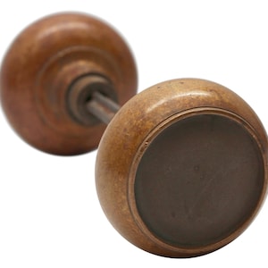 May include: A pair of antique brass door knobs with a worn finish. The knobs are round and have a simple design.