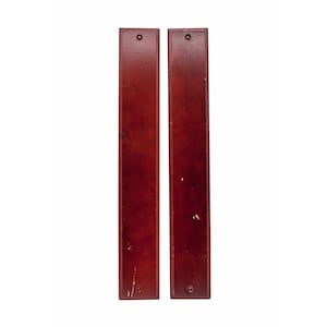 Puede incluir: Dos tiradores de puerta de madera en un acabado caoba rojo oscuro. Los tiradores son rectangulares y tienen un borde ligeramente redondeado. Ambos están montados sobre un fondo blanco.