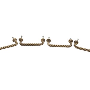 May include: Set of five antique brass cabinet pulls with a rope design. Each pull has a screw on each end for installation.