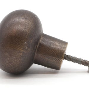 Puede incluir: Un pomo de armario redondo de bronce con una superficie texturizada y un tornillo para la instalaci&oacute;n.