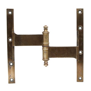 May include: Brass door hinge with a decorative design. The hinge is made of two plates with a connecting arm. The plates have multiple holes for screws.
