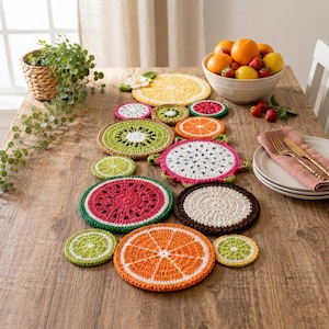 May include: A collection of round, crocheted coasters and mats designed to resemble various sliced fruits, including watermelon, orange, kiwi, dragon fruit, and lime. The colorful, textured fiber pieces are arranged in a decorative pattern.