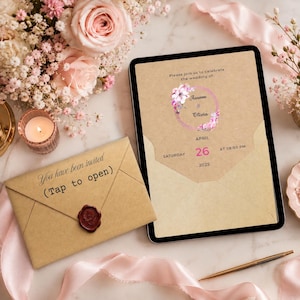 May include: A digital tablet displaying a wedding invitation on a kraft paper background with floral accents, featuring the text 'Please join us to celebrate the wedding of: Aaroon & Olivia, APRIL 26 2025'. Beside it lies a matching envelope with a wax seal.
