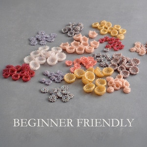 A second detailed photo of numerous tiny beaded flowers arranged on a grey background, showing variations in shape, size and color. The textured seed bead surfaces and cup-shaped petals are clearly visible.