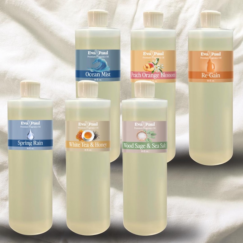 May include: Six clear bottles of Eva Paul Premium Fragrance Oil with white caps and labels. Scents include Ocean Mist, Peach Orange Blossom, Re-Gain, Spring Rain, White Tea & Honey, and Wood Sage & Sea Salt.