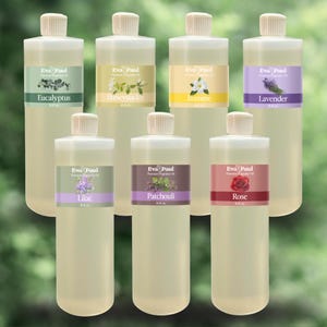 May include: A collection of seven clear plastic bottles with white caps, each labeled with a different floral fragrance. The labels feature the brand "Eva Paul" and the scents: Eucalyptus, Honeysuckle, Jasmine, Lavender, Lilac, Patchouli, and Rose.
