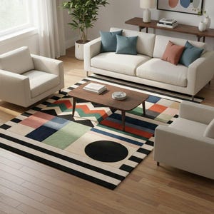 May include: A modern living room setup featuring a cream-colored sofa and armchairs, a dark wood coffee table, and a colorful geometric rug. The rug has a black and white striped border and a large black circle in the center. Decorative pillows in blue and coral add pops of color.