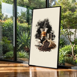 May include: Framed art print featuring a coffee-making scene. A glass pour-over coffee maker, a white cup and saucer, a stainless steel carafe, and a burlap sack filled with coffee beans are depicted. A black abstract shape is behind the coffee maker.