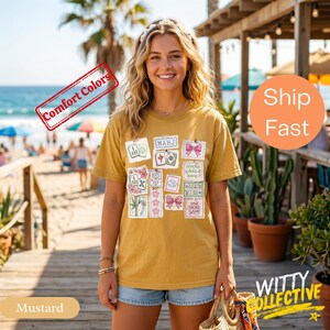May include: Mustard-colored t-shirt with various graphic patches, including text and illustrations. The shirt features the text "MAHJ" and "ONE MORE GAME". The words "Comfort Colors" and "Ship Fast" are also visible.