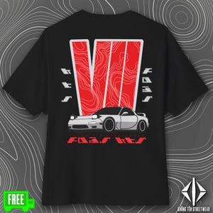 May include: Black t-shirt featuring a white and red graphic design. The design includes a stylized car illustration, the word "FAST" in red, and the text "KHÔNG TÊN STREETWEAR". The shirt has a crew neck and short sleeves.