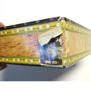 Sticker on edge of box that continues the cigar box theme of the graphics.