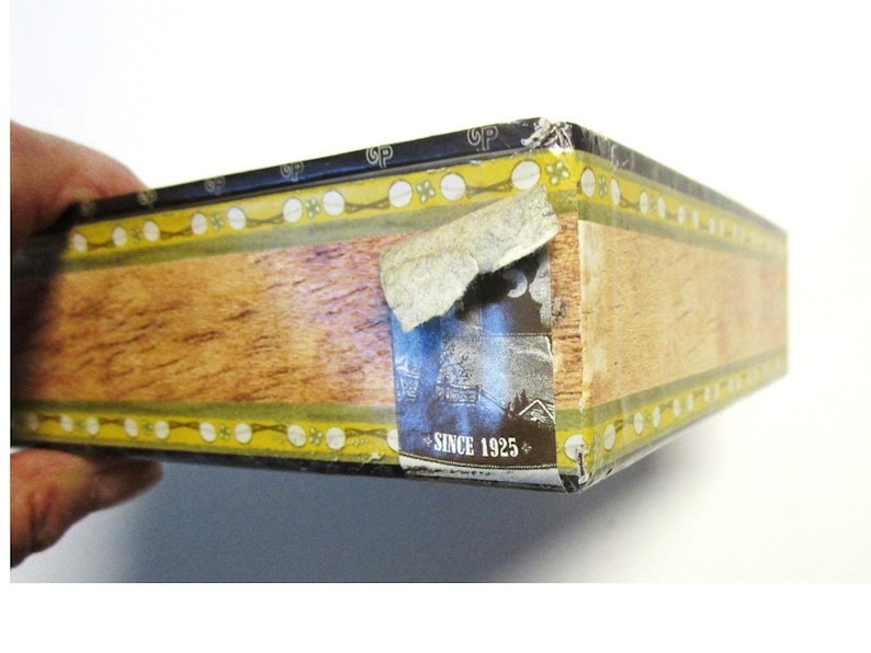 Sticker on edge of box that continues the cigar box theme of the graphics.