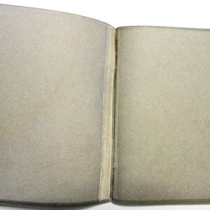 Inside cover of pamphlet.  It appears to have a broken binding or become unglued.  However, that is all part of the graphic design.  The pamphlet is in very good condition.
