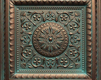May include: Square, bronze-colored decorative ceiling tile with a detailed floral and scroll design. The tile features a central medallion with radiating leaves and flowers, surrounded by ornate patterns and a teal-colored background.