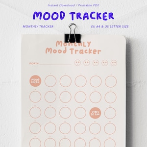Könnte beinhalten: Ein druckbares monatliches Stimmungsprotokoll, das mit einer schwarzen Büroklammer befestigt ist. Das Papier enthält den Text Monthly Mood Tracker, eine Zeile für den Monat, fünf Gesichtsausdruck-Symbole und ein Raster aus nummerierten Kreisen.