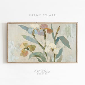 May include: A framed floral painting featuring iris flowers in shades of white, yellow, and purple, with green leaves. The artwork has a textured, impressionistic style. The words "FRAME TV ART" and "Old Masters DIGITAL" are printed on the image.