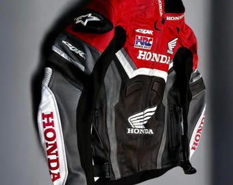 May include: A red, black, and gray Honda motorcycle racing jacket. The jacket features the Honda logo and other racing graphics in white. The jacket has a zipper closure and is made of leather.